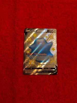 Ditto V (BUDA!!!) - Cool och glittrig Ditto V Pokémonkort! Perfekt för dig som samlar eller spelar Pokémon TCG. Kortet har 170 HP och unika förmågor som V Transformation och Stick On. Ett måste för alla Pokémon-fans som vill sticka ut i samlingen eller på spelkvällen.