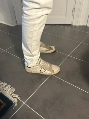 Philippe modell skor - Vita Philippe modell skor med svart undersida och bakflärp. Sulan på vänstra skon har lossnat men går att laga hos skomakare. Dom har även slitningar inuti. Vid snabb afär kan jag gå ner i pris. Mycket kvar att ge. 