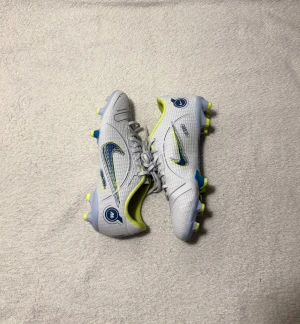 Nike Mercurial Vapor 14 fotbollsskor - Nike Mercurial Vapor 14 Academy MG fotbollsskor, aldrig använda, supersnygga och i perfekt skick, storlek 34 💕 Vita med blåa och neongula detaljer. Tyvärr följer inte kartongen med, men skorna är helt nya. Originalpris: 799 kr.  Skriv gärna om du undrar något!