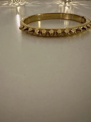 Edblad armband i guld🤍 - Säljer ett exklusivt armband från Edblad med ikoniska nitdetaljer. Ett kraftfullt men elegant statement-smycke som passar lika bra till vardag som till fest.  Armbandet är i guldfärgad metall och har en tidlös, edgy design🤍