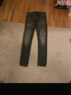 Grå slim jeans 28/32 - Säljer ett par grå slim jeans i storlek 28/32. Jeansen har slitna detaljer och en tvättad look med smal passform. Klassisk femficksmodell och knappgylf. Perfekta för dig som gillar en lite tuffare stil.
