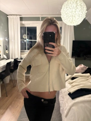 Beige croppad kofta med dragkedja - Säljer en beige croppad kofta med dragkedja framtill och två stora bröstfickor.  Koftan är från Kappahl och väldigt populär, dragkedjans hållare är borta men inget annat än så! Hör av dig 💕