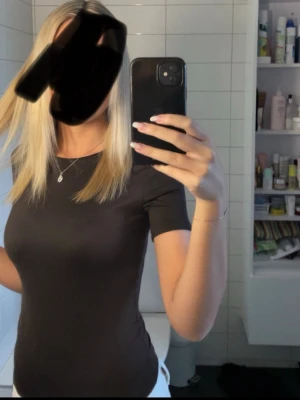 Svart tight kortärmad brun body - Säljer en brun , tight och enkel body med korta ärmar, ifrån New Yorker. Andvänd 2 gånger, köptes i sommras