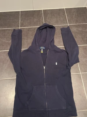 Ralph lauren zip hoodie  - Säljer min mörk blåa zip up hoodie från Ralph lauren. Mycket bra skick inga skador på hoodien. Ny pris kostar den 1800. Priset är inte huggit i sten men vill ha seriösa bud.