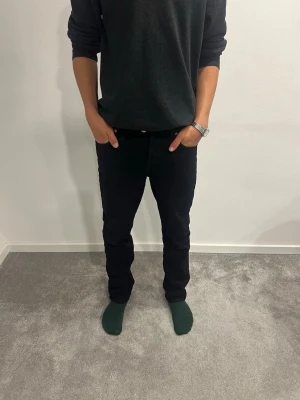  Levi's jeans - Säljer ett par svarta Levi's 501 jeans med klassisk femficksdesign och rak passform. Jeansen har en stilren look och är tillverkade i ett mjukt jeansmaterial som sitter riktigt snyggt. Perfekta för dig som gillar en clean och enkel stil. W28 L30