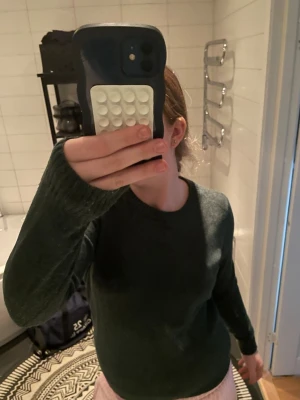 Mörkgrön stickad tröja från VILA - Mysig mörkgrön stickad tröja från VILA i storlek M. Tröjan har rund halsringning, långa ärmar och ribbade muddar vid ärmslut och nederkant. Perfekt för kyliga dagar och enkel att matcha med olika outfits.