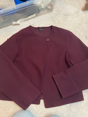 Vårjacka - Säljer min jättefina vinröda kappa med en stylish knapp längst upp, men man kan ha den uppknäppt med! Från Gina tricot, är i jättefint skick nästan ny!💞💞