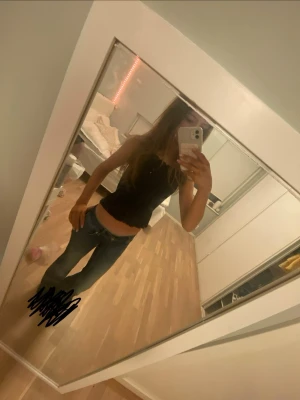 Svart croppad linnetopp - Säljer en svart croppad linnetopp med vågig kant nertill. Toppen är ärmlös och har en enkel, stilren design som passar perfekt till jeans eller kjol. (Produkten är i str 152 men passar som en str xs/xxs ) 