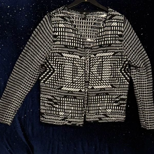 Stilren svartvit H&M-kofta i mönstrad design  -  Snygg svartvit mönstrad kofta från H&M i storlek M. Stilren modell med modern grafisk design – passar både vardag och fest. Bekvämt material med lätt struktur och rak passform. Mått: bröst 48 cm, längd 62 cm, ärm 60 cm. Mycket fint skick, knappt använd. Från rök- och djurfritt hem. ✨.                     Exklusiv design ✅ Hög kvalitet 📦 Skick:  NY 🚚 Snabb leverans  🚀 Passa på innan den är borta – slå till nu!