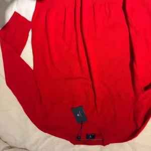 Röd kashmirtröja från GANT XL - Snygg röd tröja från GANT i lyxig ull- och kashmirblandning. Klassisk rund halsringning och ribbade muddar. Perfekt för dig som vill ha en stilren och bekväm look med premiumkänsla. Storlek XL.