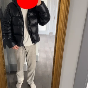 Svart pufferjacka från GANT, stl S - Säljer en svart pufferjacka från GANT i storlek S. Jackan är dunfylld med 100% certifierat dun, har en glansig finish och dragkedja framtill. Klassisk boxig passform med långa ärmar och hög krage. Perfekt för kalla dagar när du vill hålla stilen. Den är oversized så passar till M, har aldrig använt den då den var för stor för mig