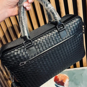 Svart flätad datorväska i skinn - Snygg svart datorväska med flätad design och stilrena detaljer. Väskan har både handtag och justerbar axelrem, samt en praktisk dragkedja framtill. Tillverkad i skinn och passar perfekt för att bära laptop och viktiga prylar till plugget eller jobbet.