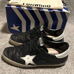 Golden goose sneakers  - Hej, Säljer nu mina otroligt snygga Golden Goose sneakers i en eftertraktad färg och model. Storlek: EU 43 / UK 9 Skick: 7/10, bra skick över lag, förutom några få skavanker ( vid hälsen bland annat, men inte så illa) samt att jag tidigare lagat en liten slitning vid hälen på skon med hjälp av självhäftande lagningslappar. Nypris: runt 5000kr.  Hör av er för mer bilder och övrig information! Mvh, Elton