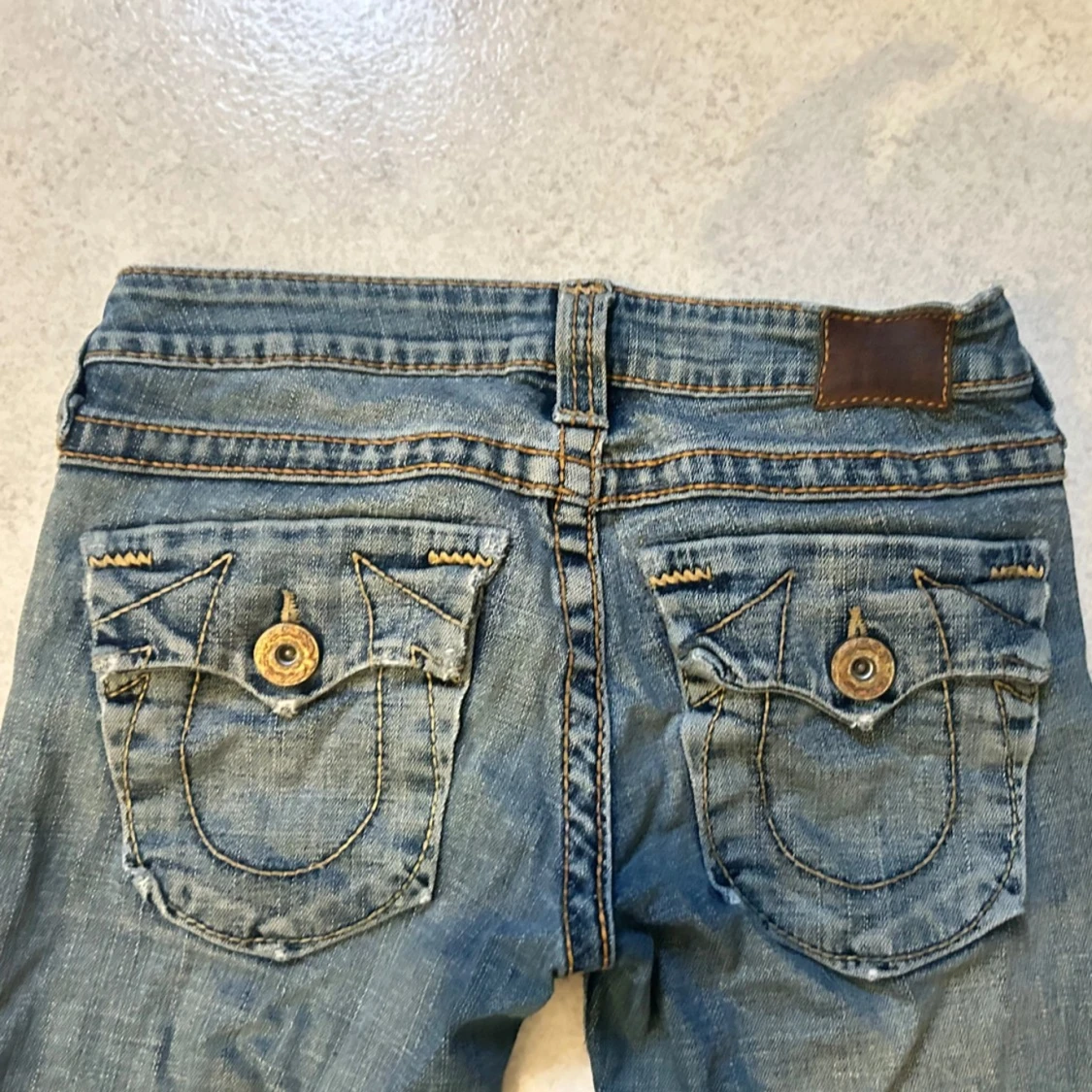 Blå jeans med broderade bakfickor