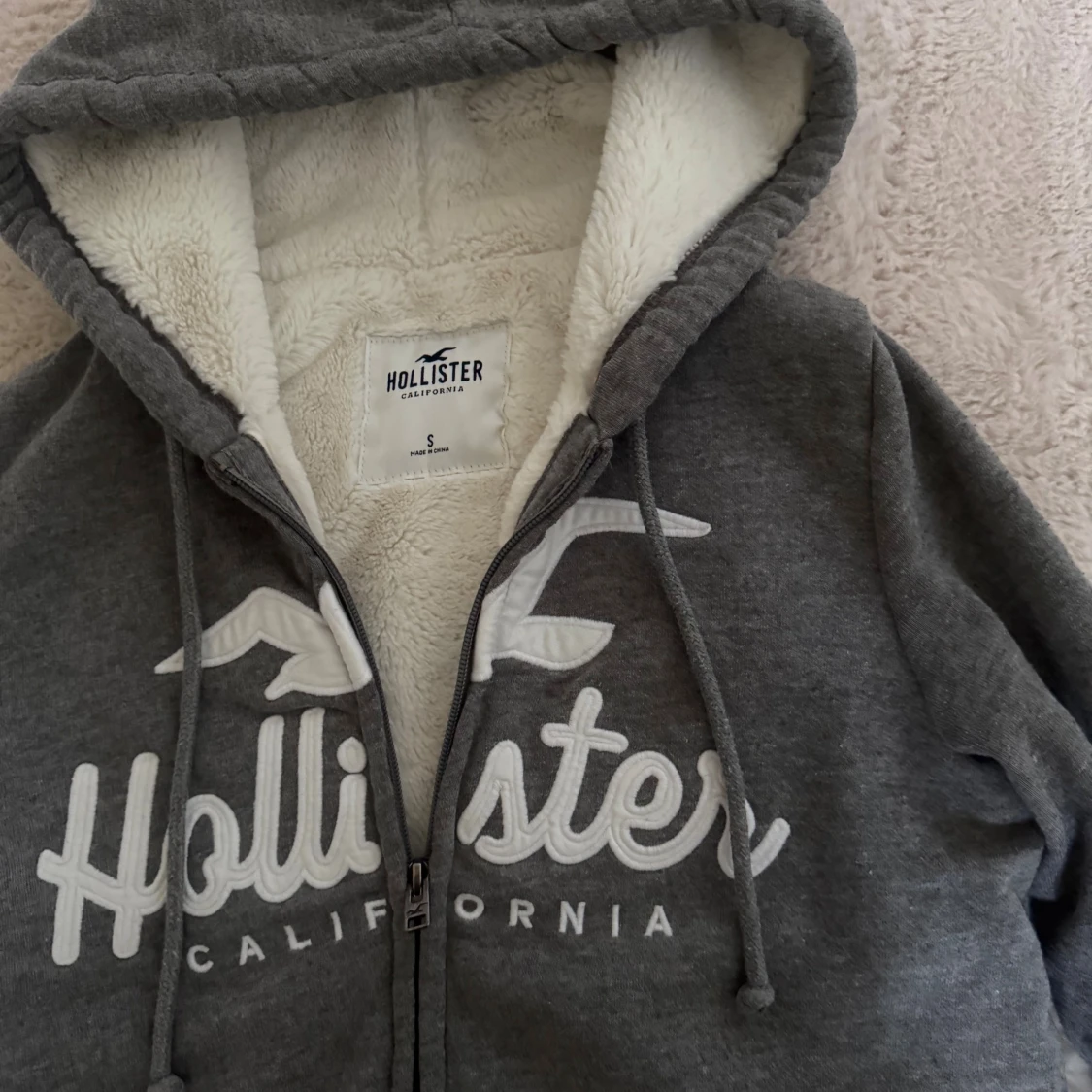 Grå zip up hoodie från Hollister med teddyfoder - 1