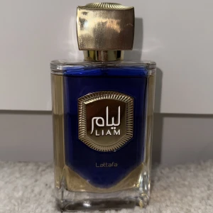 Liam Blue Shine Eau de Parfum - Liam Blue Shine från Lattafa är en Eau de Parfum i en snygg blå och guldig flaska. Volym: 100 ml. Perfekt för dig som vill sticka ut med en modern och exklusiv känsla.