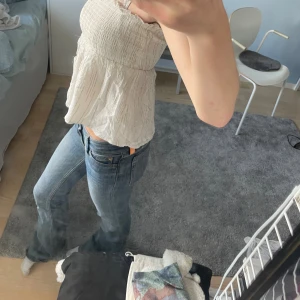 Vit volang topp - Säljer en söt vit topp ifrån Gina med guld detaljer. Superfin topp som funkar både till festligare och mer avslappnade tillfällen! 