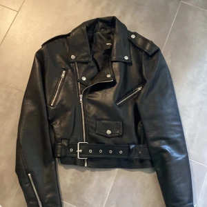 Svart skinnjacka från Bik Bok oanvänd  - Snygg oanvänd svart croppad skinnjacka från BikBok i storlek L. Säljer då den är för stor för mig. Passar M om man vill ha en lite mer oversize look.