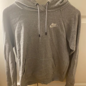 Grå Nike hoodie med huva  - Grå hoodie från Nike med huva. inget fel på den men kommer inte till användning längre.