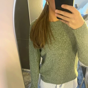 Grön stickad tröja från Vero Moda - Mysig grön stickad tröja från Vero Moda med rund halsringning och ribbade muddar. Perfekt för lager-på-lager och chill dagar. Enkel och stilren design som funkar till allt. Säljs i storlek S.