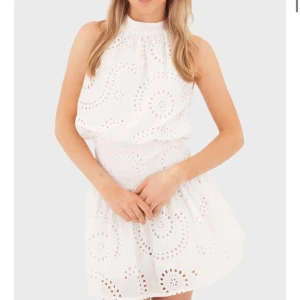 Vit kort klänning med broderade detaljer, studenten!! - Superfin vit kort klänning med broderade hålmönster i cirklar. Klänningen har hög hals, är ärmlös och har en lätt utställd kjol. Perfekt för studenten och sommaren! Aldrig använd, säljer då för liten