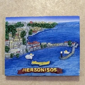 Magnet från Hersonisos - Kylskåpsmagnet med motiv från Hersonisos, Grekland. Produkten är en vacker souvenir. Den har en färgglad 3D-design på framsidan och en magnet på baksidan. Inga synliga defekter eller slitage. Perfekt för att dekorera kylskåpet eller som minne från resan.