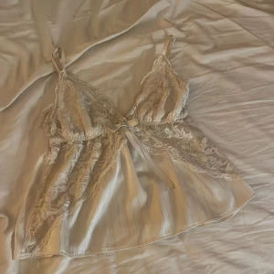 Vit spetsig linnetopp med rosett - Så söt. Kan användas i vardagen och ha som sov tröja 