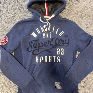 Superdry Hoodie - Märke: Superdry Skick: 9/10 Färg: Blå med vit- och röda detaljer Storlek: S  Hör av dig vid andra funderingar eller frågor! Priset kan ändras vid snabbt köp!
