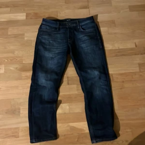 Mörkblå jeans från Jack & Jones - Feta mörkblå jeans från Jack & Jones. Jeansen har raka ben och normal passform, perfekt för en avslappnad stil. Tillverkade i slitstarkt denim-material, Archive 