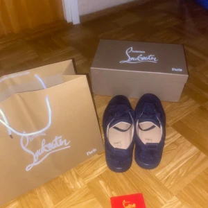 Christian Louboutin skor - Säljer ett par mörkblå sneakers från Christian Louboutin, skorna är i bra skick och nästan helt nya, då jag säljer dem åt en vän så kan mer bilder dröja lite extra men du är alltid välkommen att fråga!!!