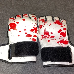 Kenka Limited Edition MMA-handskar - Unika MMA-handskar från Kenka Limited Edition Series #1. Handskarna är vita med röda färgstänk som ger en cool och edgy look. De har öppna fingrar, svart kardborreband och är tillverkade i skinn med vadderad insida för extra komfort. Perfekt för dig som vill sticka ut på träningen. De är väldigt gamla. Förmodligen mera samlarobjekt