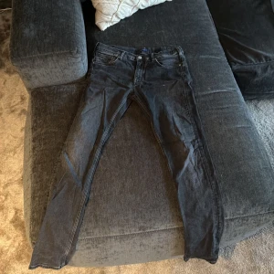 Svarta skinny jeans från GANT 170 cm - Säljer ett par svarta jeans från GANT i skinny fit med klassisk femficksdesign och knappgylf. Jeansen har en mörk tvätt och är tillverkade i stretchigt bomullsmaterial för skön passform. Perfekt för dig som gillar en smal siluett.