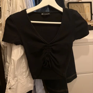 Svart croppad topp med snörning  - Svart croppad topp med snörning från Zara. Bild två är samma topp fast i vitt som jag också säljer