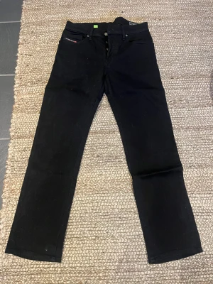 Svarta Diesel D-Mihtry jeans straight - Svarta jeans från Diesel, modell D-Mihtry med straight fit. Klassisk femficksdesign och diskreta detaljer. Jeansen är tillverkade i stretchigt denim för extra komfort och har en stilren look som passar till sneakers eller boots.