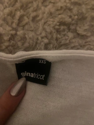 Vit topp med knyte där fram från Gina - Superskön