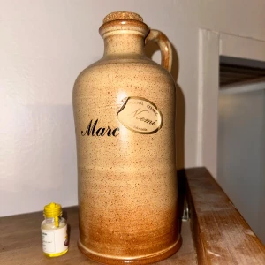 Noemi Keramikflaska - Bilden visar en keramikkanna för dekoration. Keramikflaska från Noemi med texten "Marc".