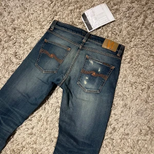 Nudie jeans lean dean helt nya med lappar unik wash slitningar slim fit herr w30 - Nudie jeans slim fit modell lean dean. Riktigt fet och unik wash med sköna slitningar. Nytt skick med lappar. Storlek W30 L 30, postas antigen samma dag som köp eller dagen därpå🙌💯