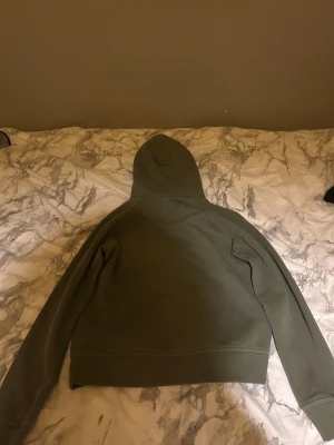 Olivgrön hoodie från Gant - Olivgrön hoodie från Gant med broderad logga och texten 'American Sportswear' på bröstet. Tröjan har Luva, känguruficka och ribbade muddar. Perfekt för chill dagar och snygg streetstyle.