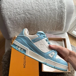 Louis Vuitton blå och vita sneakers - Säljer ett par Louis Vuitton sneakers, sparsamt använda finns en flaw i utkanten på hälen, ingen som syns eller märks vid användning.  ALLT OG INGÅR (ni som kan trainers vef de äkta) - skicka pm vid fråga eller fundering!