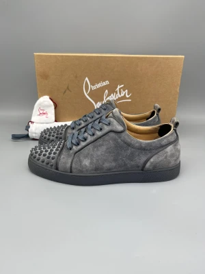 Christian Louboutin Louis Junior Spikes Sneaker Grå - • The shoes have been gently used and are in really good condition  • Size: 43.5 (fits 44–44.5)  • Color: Grey  • Retail price: 9500 SEK / 795€  • Box, new laces & extra spikes/studs included  Ytterligare info: hälskydd har adderats inuti båda hälarna för att förebygga mer nötning 