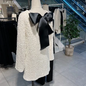 Virala paljettklänningen H&M - Virala paljettklänningen från H&M med glittrande paljetter över hela ytan och en stor svart rosett i satin baktill. Strl S