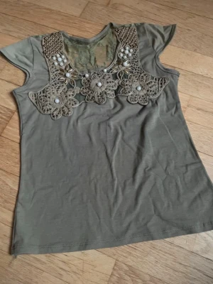 Olivgrön topp med spets och pärlor - Köpte på vinted men passade inte. Storlek S men märket står ej.       Pris kan diskuteras.                                            Skriv för fler frågor💕
