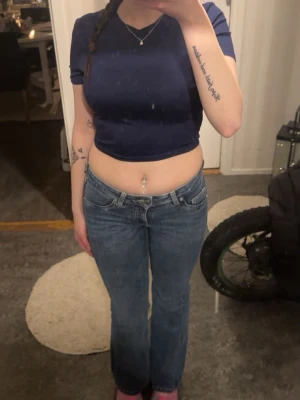 Mörkblå croppad t-shirt - Säljer en mörkblå croppad t-shirt med korta ärmar och rund halsringning. Toppen har en enkel och stilren design som passar perfekt till jeans eller kjol. Materialet känns mjukt och stretchigt, vilket gör den bekväm att bära hela dagen.