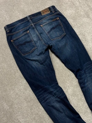 Nudie Grim Tim - Nudie Jeans | Modell: Grim Tim | Skick 9/10 mycket bra | *hål vänster ficka | Nypris ca 2500kr | Mitt pris 749kr | Midja: 44cm | Ytterbenslängd: 108cm | Benöppning: 19cm | Lår: 28cm | Kom gärna pm vid frågor eller funderingar | Postas eller möts upp i Gävle!