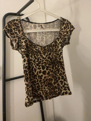 Leopardmönstrad topp med kort ärm - Snygg topp med leopardmönster och djup rundringning från Nelly.Kortärmad och figurnära passform, perfekt för dig som vill sticka ut. Tillverkad i mjukt och stretchigt material som känns skönt mot huden.