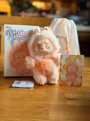 Pop Mart The Monsters Labubu Big into Energy Happiness - HAPPINESS  Underbar och fluffig Labubu Happiness från The Monsters – Big into Energy-serien. Endast öppnad i botten för fotografering, annars helt ny. Köpt från PopMarts officiella AliExpress-butik. Förpackningen limmas igen innan jag skickar den och skickas tryggt emballerad.