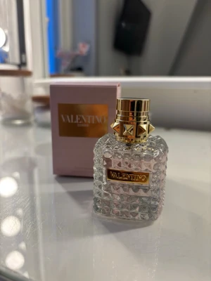 Valentino Donna parfym - Lyxig parfym från Valentino med elegant, kristallmönstrad glasflaska och gulddetaljer. Flaskan har en fyrkantig form och ett exklusivt lock med nitar. Kommer i en ljusrosa kartong med guldfärgad logga. Kan släppa den för 340kr vid snabbt köp🤗