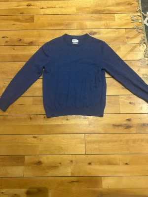 These Glory Day Superior Merino - En stilren blå stickad tröja med rund halsringning och långa ärmar. Tröjan har ribbstickade muddar vid ärmslut och nederkant. Perfekt för lager-på-lager och enkel att matcha med jeans. Priset är inte fast. Nypris 1100kr.