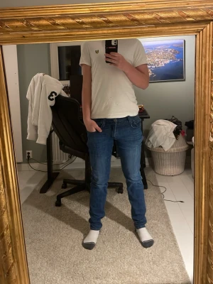 Replay Anbass blå jeans, W29 L32 - Snygga blå Replay Anbass jeans med klassisk femficksdesign och diskreta slitningar. Jeansen har raka ben och normal passform, med tydliga kontrastsömmar och Replay-logga på myntfickan. Perfekta för dig som gillar stilrena och bekväma jeans med en grich och rik still 🍾🍾🔥🔥🔥🔥