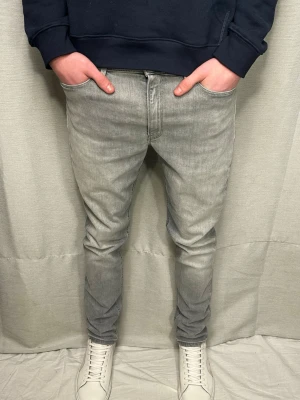 Gråa dundup jeans - Säljer ett par grå dondup jeans i modellen iris. Storleken W32 L32 (men sitter mer som 30 i midjan. Modellen på bilden är 183 o väger ca 70 kg. Skriv vid minsta fundering.